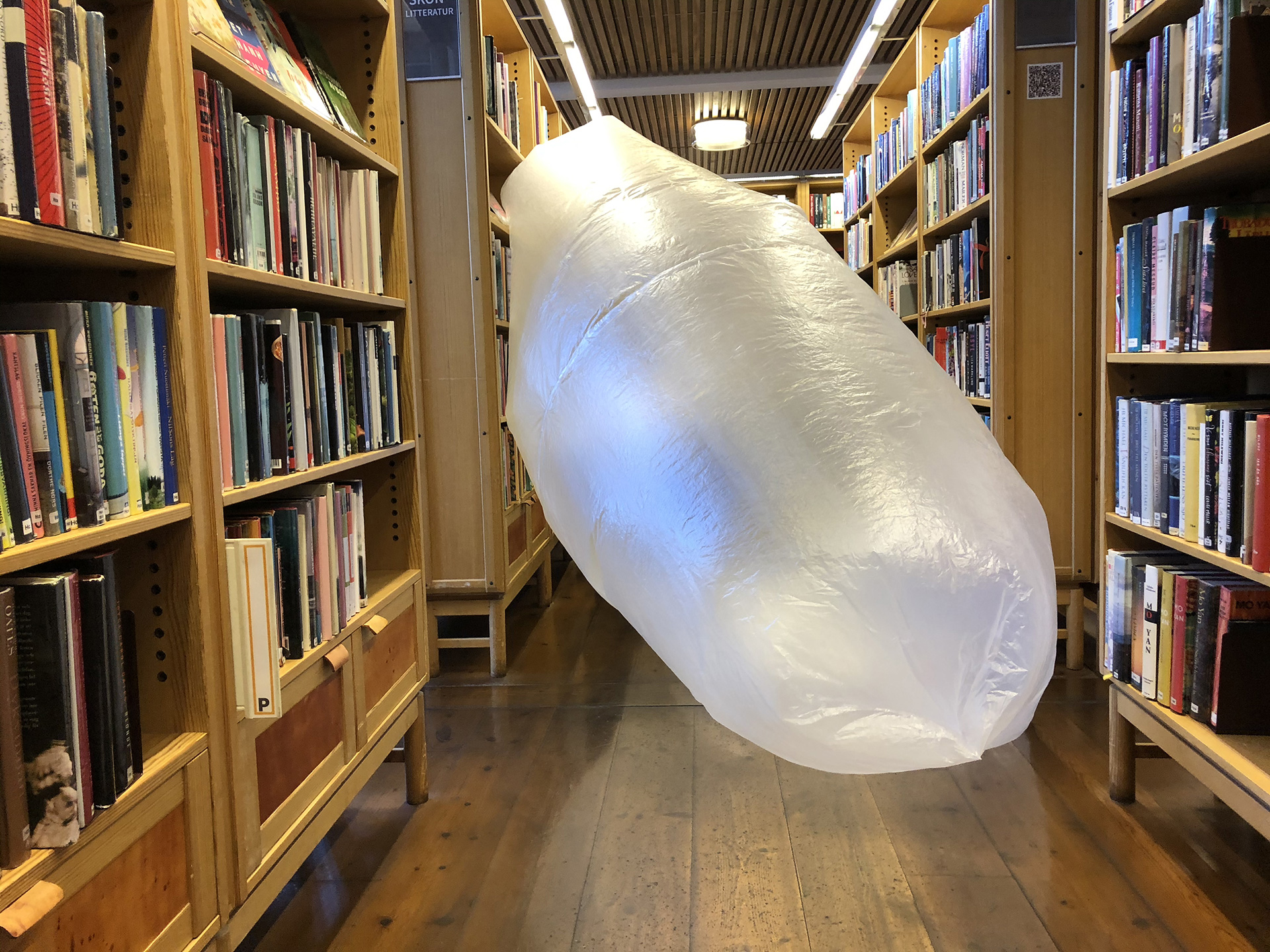 Jättestor vit ballong i Skövde stadsbibliotek. Nicole Neidert, Linnea Bågander och Joakim Envik Karlsson laborerar med "kostym i miljö" under residenset STM_IRL Spaces.